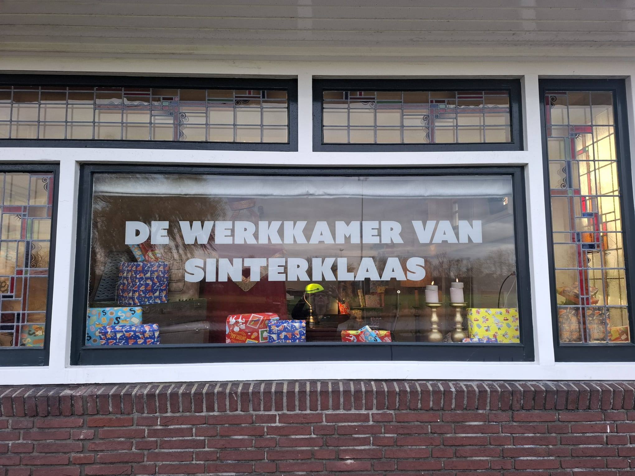 De werkkamer van Sinterklaas in Bedum, gezien van buitenaf door het raam met pakjes.